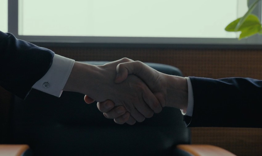 Two professionals shaking hands in an office setting