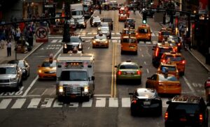 A bustling city street filled with numerous cars and taxis navigating through traffic