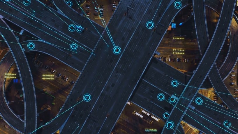 Aerial view of a bustling city with visible traffic lights and cars navigating the streets below
