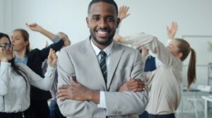 A diverse team celebrates a successful project, with one leader calmly observing the joyful atmosphere