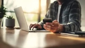 Person using a laptop and smartphone digital wallet for secure online payment at home