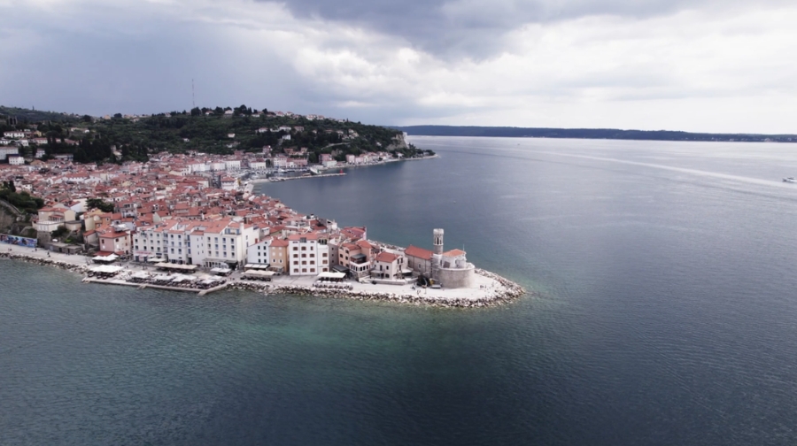 A coastal town in Slovenia with red-roofed buildings by the sea