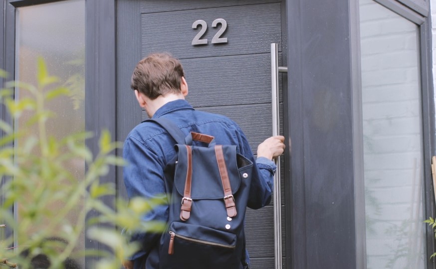 Man closing entrance door of his apartment