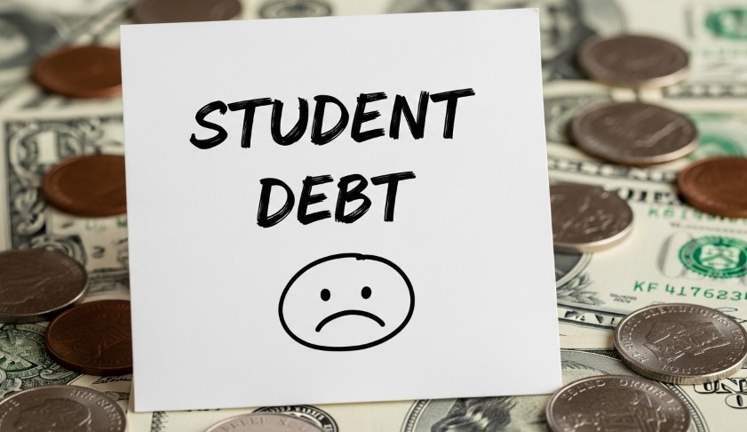 Paper that says "Student debt"with sad emoticon on it, money in the background