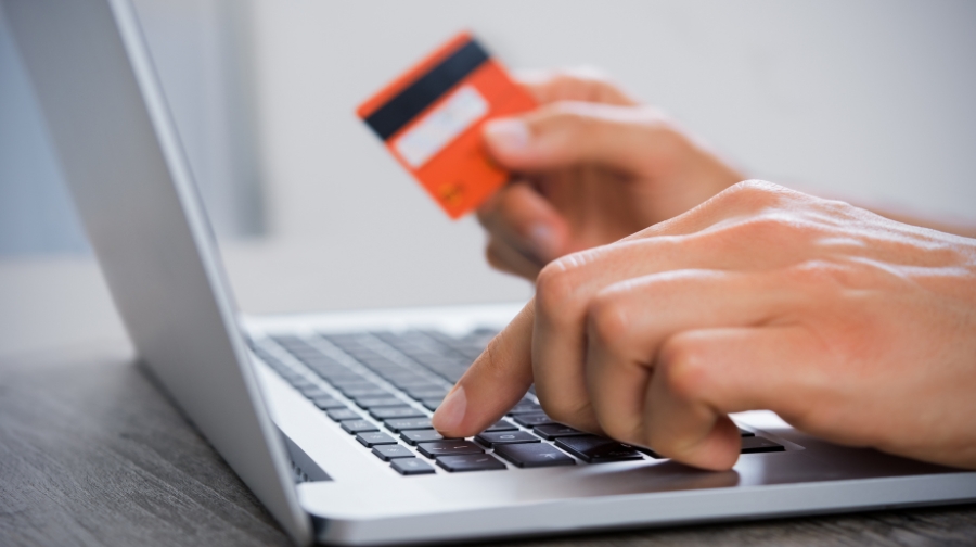 Person making an online payment with a credit card to manage student loan repayment