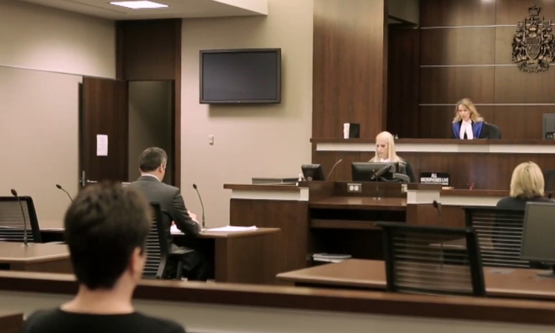 A courtroom scene with individuals seated at desks