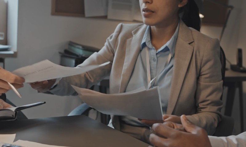 FBI meeting, woman handing over a paper report