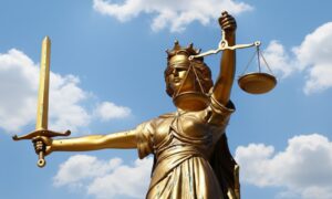 Statue of Lady Justice holding a sword in one hand and scales in the other