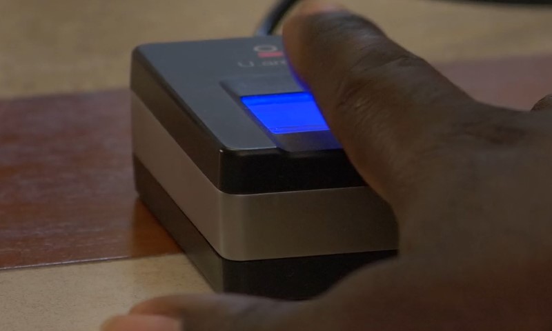 A close-up of a hand using a fingerprint scanner