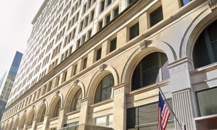 A building featuring numerous windows and a flag prominently displayed at the front entrance