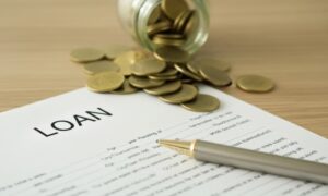 Loan application form displayed alongside a stack of coins