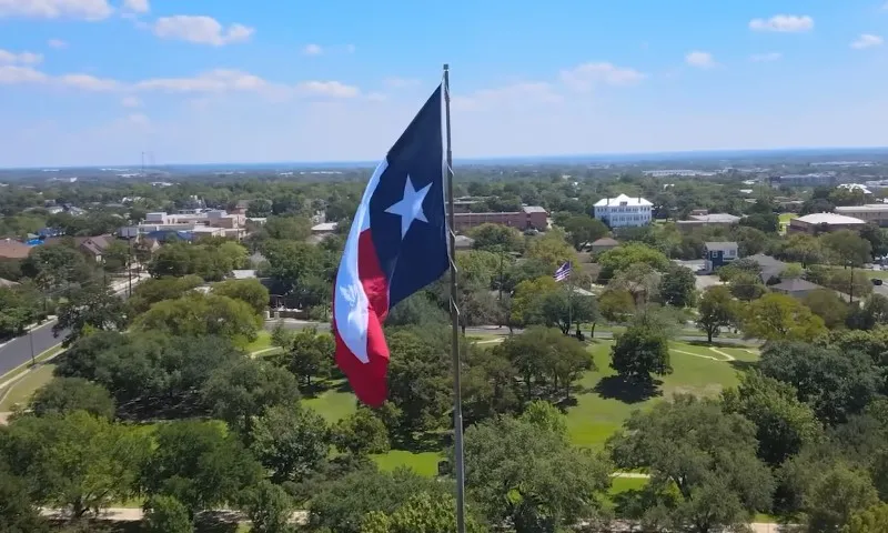 Aerial view of the Texas flag waving over the city of Frisco