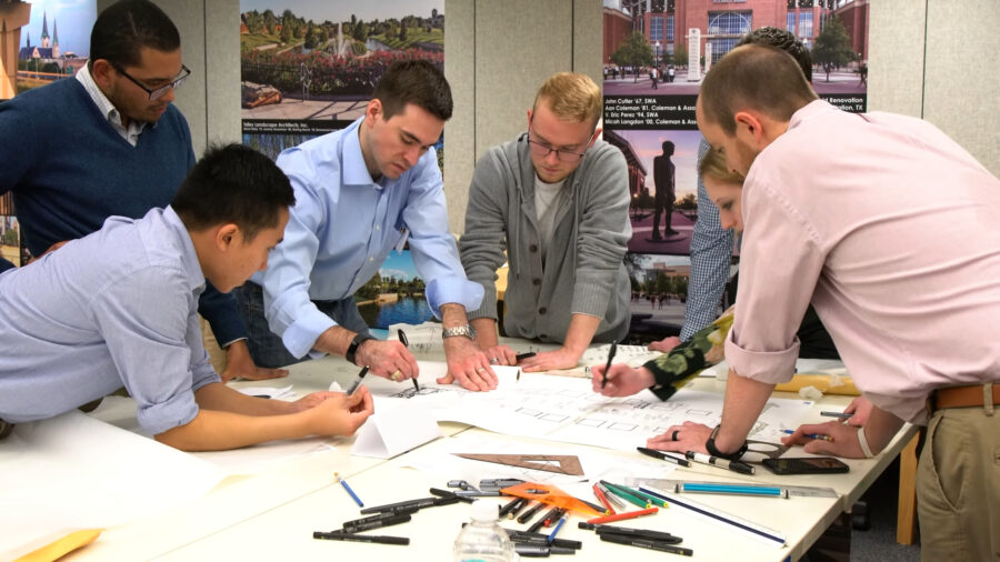 A group of men collaborating on a project around a table
