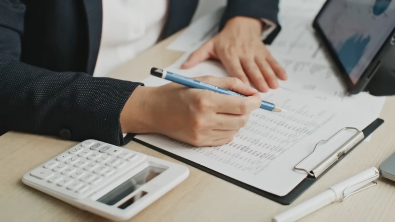 A person reviewing financial documents with a calculator, representing corporate income tax planning in Delaware