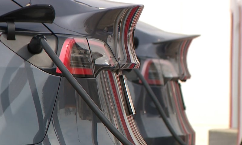 Two black electric cars charging at the station 