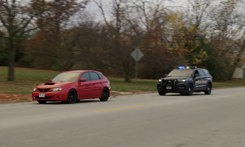 Police car chasing red car on the road