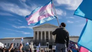 A demonstrator waves a large transgender pride flag in front of the U.S. Supreme Court