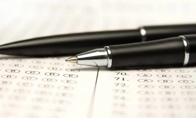Close-up of a multiple-choice test with two black pens lying on top