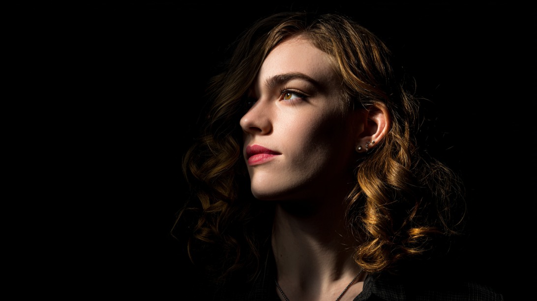 Portrait of a woman in side profile against a dark background