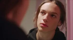 Close up of a young person listening intently to someone off camera indoors