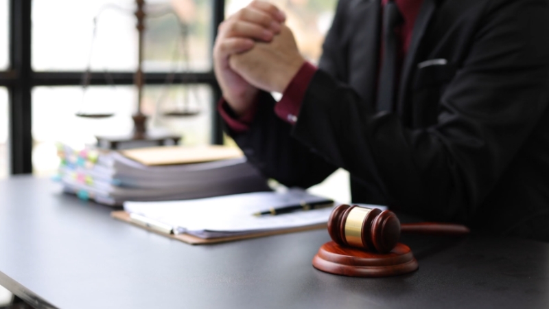 Attorney seated at a desk with legal files and a gavel, representing a federal tort claim case