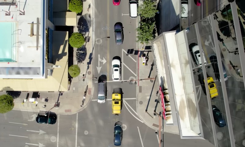Aerial view of a busy city intersection with several cars