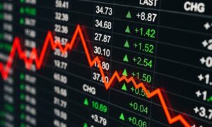 Stock market screen displaying fluctuating numbers and a red downward trend line