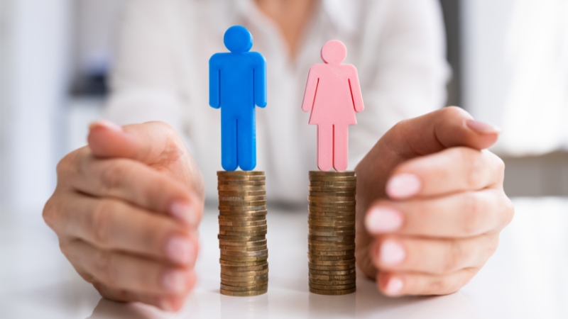 Hands holding coin stacks with male and female figures on top