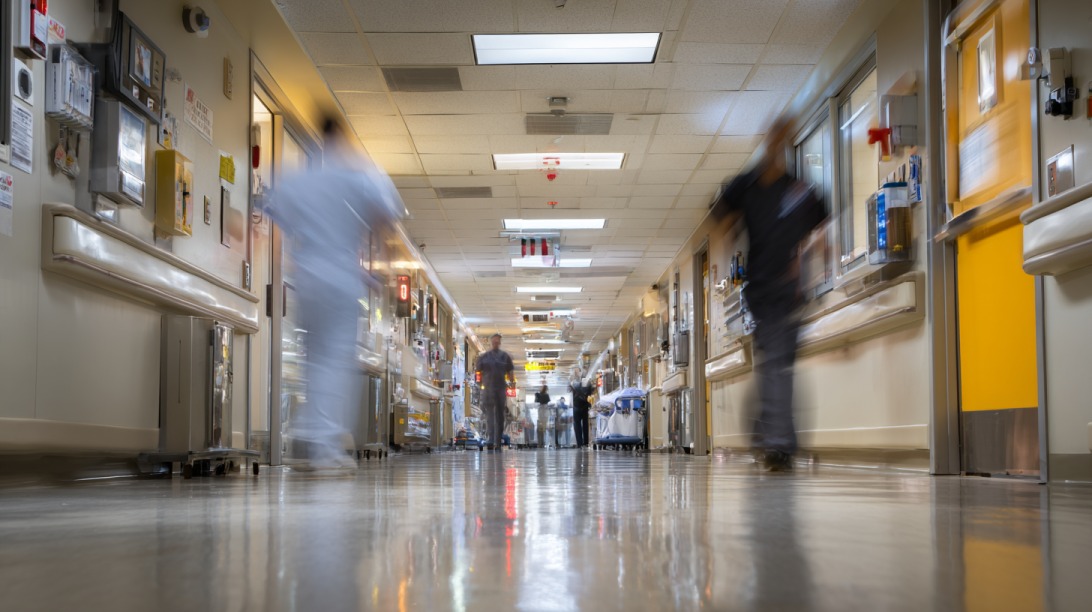 Hospital hallway with medical staff moving quickly between patient rooms