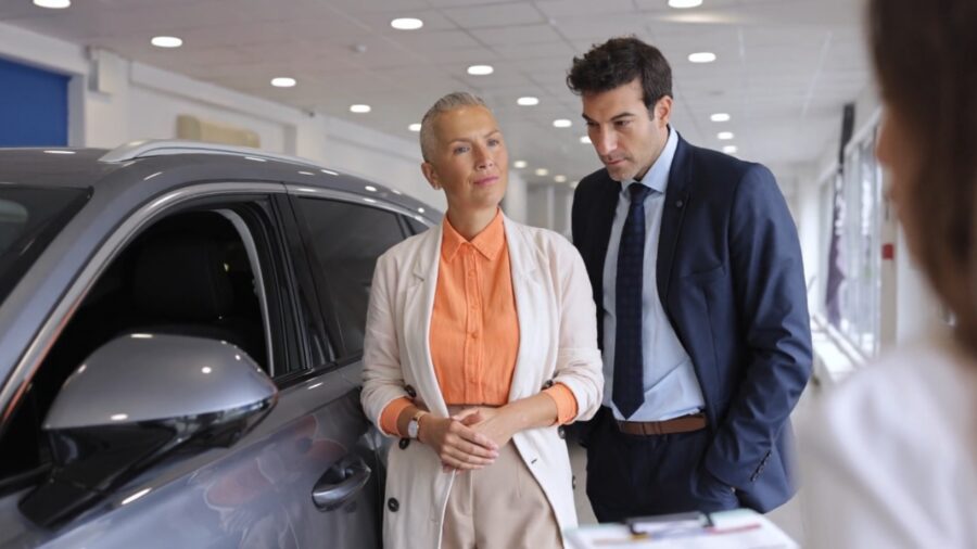 Buyers review a new car at a dealership as drunk-driving detection rules approach future vehicle requirements