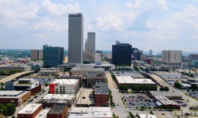 Tulsa skyline with tall skyscrapers, smaller brick buildings, and parked cars