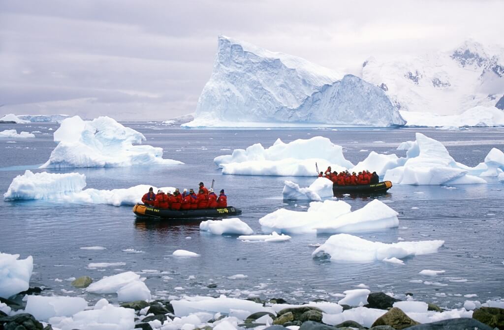 Antarctica tourism expedition boats navigating through floating icebergs in polar waters