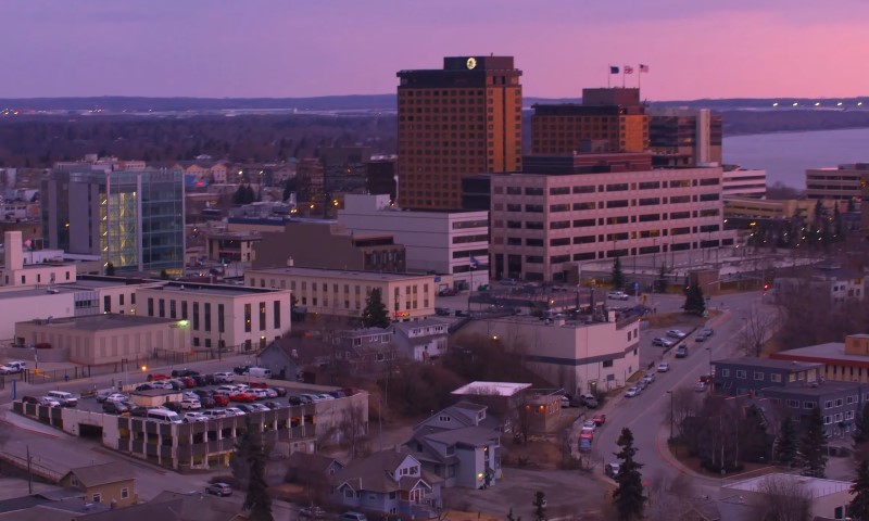Cityscape at dusk with buildings and residential areas under a purple sky