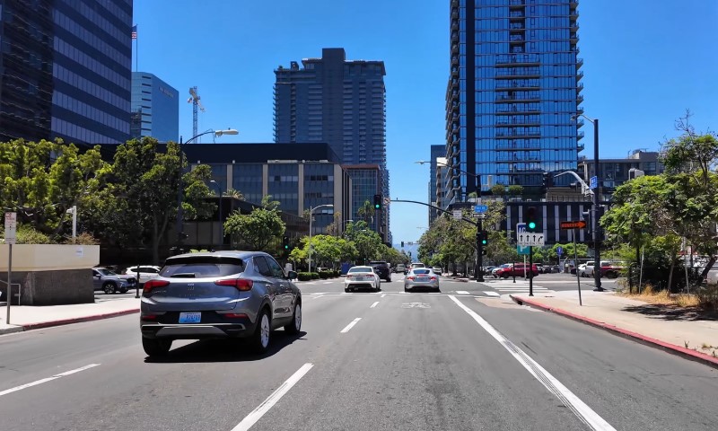 City street scene with modern high-rise buildings under a clear blue sky