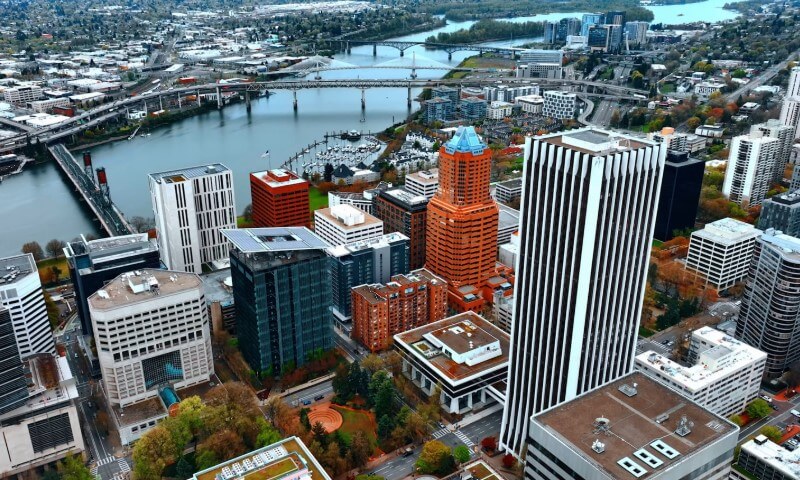 Aerial view of a cityscape with a river, bridges, and high-rise buildings
