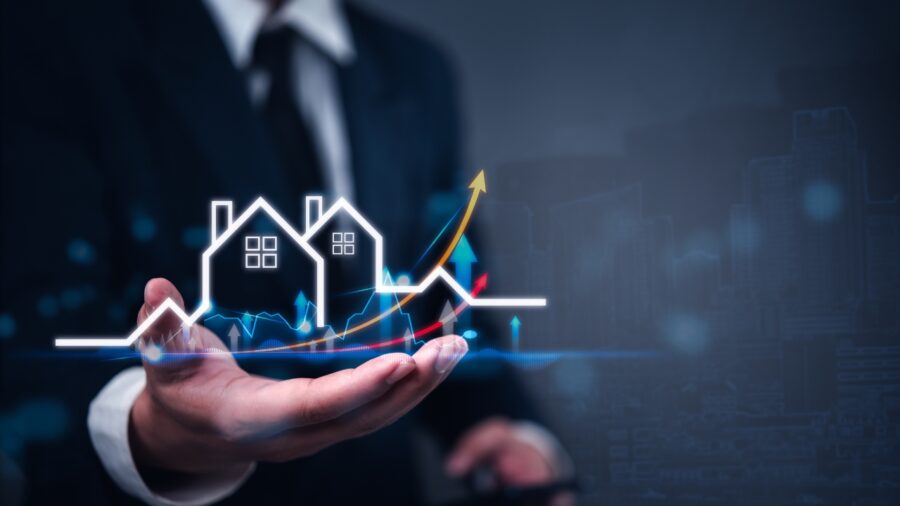 Real estate growth chart above a businessperson’s hand
