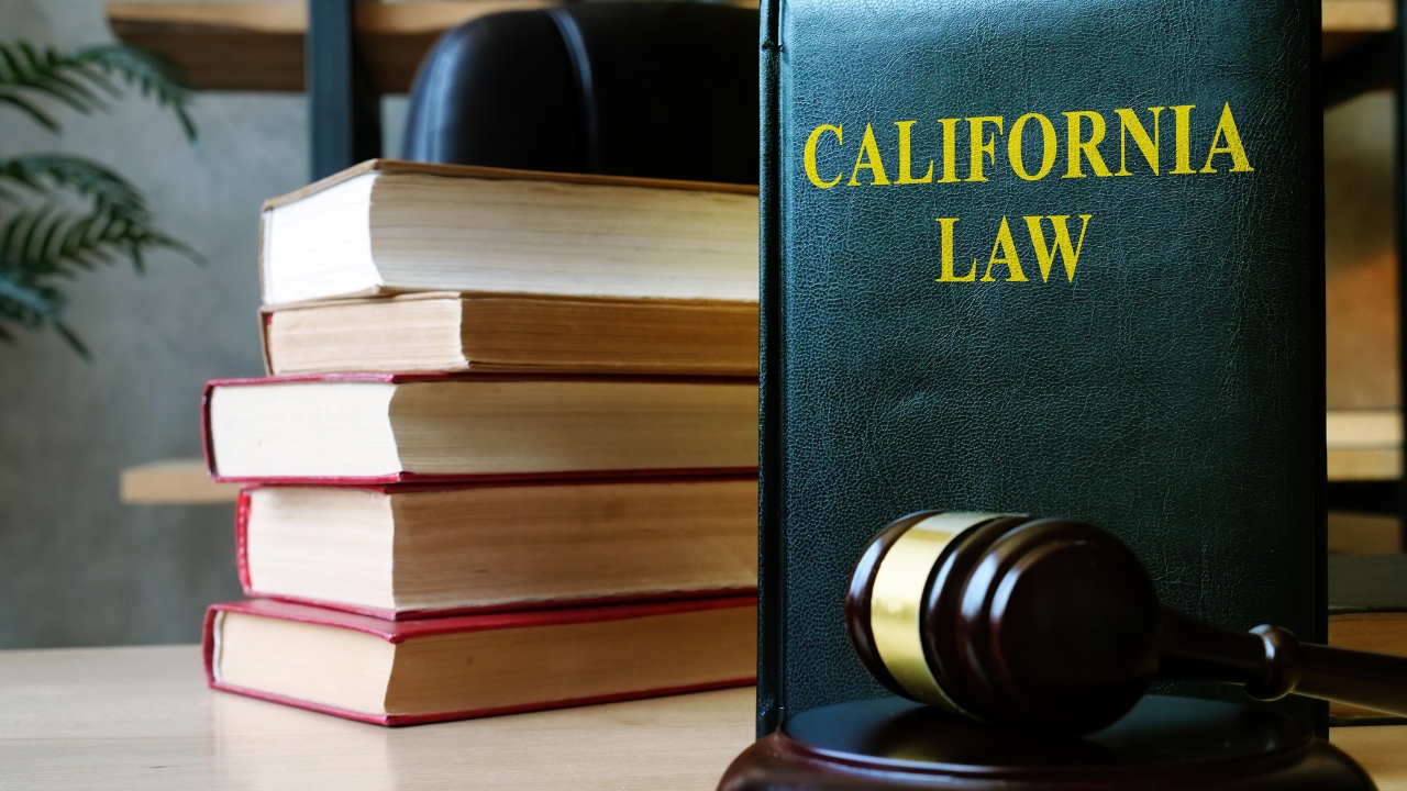 California law book and judge’s gavel on a legal office desk.