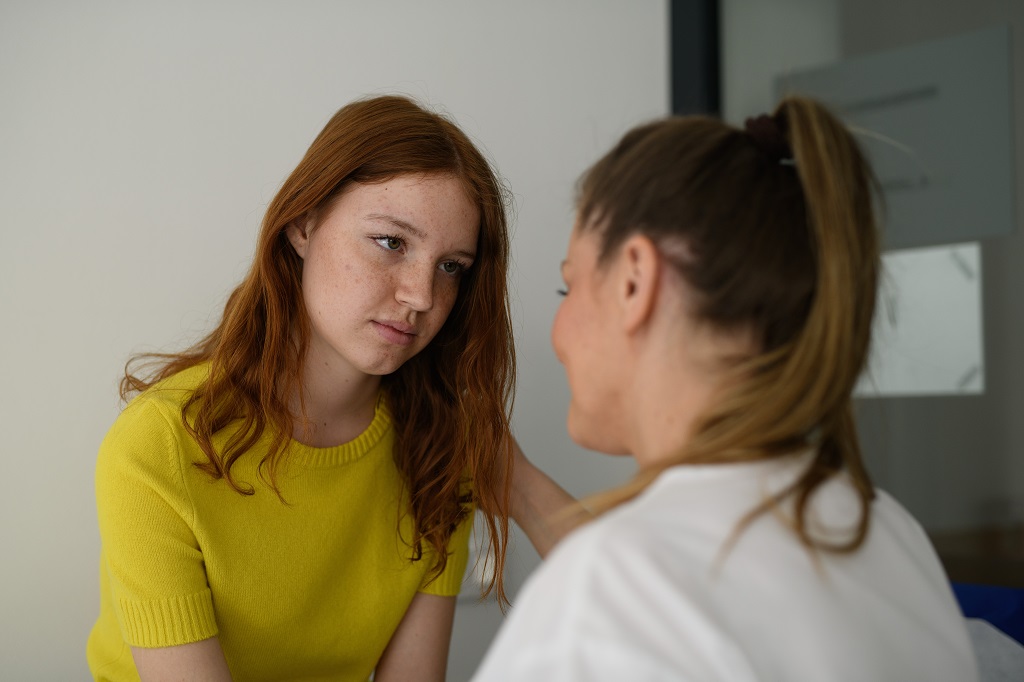 Young woman speaking with a counselor during a difficult conversation about delayed abuse disclosure