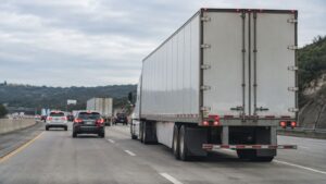 Heavy Trucks - White semi-truck driving on a busy highway.