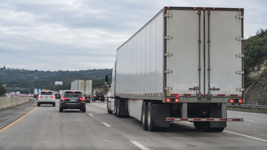Heavy Trucks - White semi-truck driving on a busy highway.