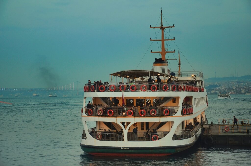Large passenger ferry docked with people on board