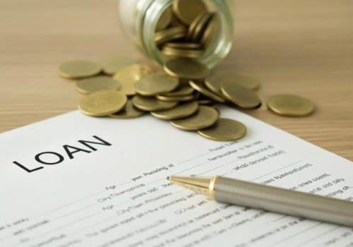 Loan application form displayed alongside a stack of coins