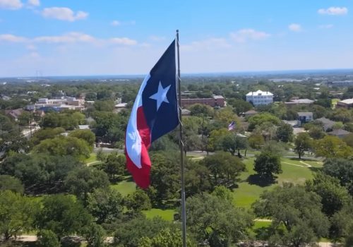 Aerial view of the Texas flag waving over the city of Frisco